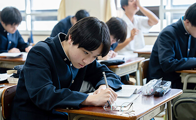 机に向かって課題に取り組んでいる学生